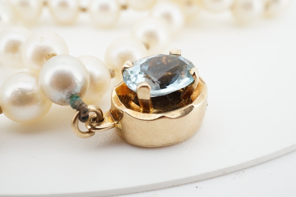 A cultured pearl and aquamarine necklace, composed of a single strand of cultured pearls, to a gold clasp set with an oval aquamarine, length 53.5cm, Condition: in good condition, minor wear, minor variations in pearl co